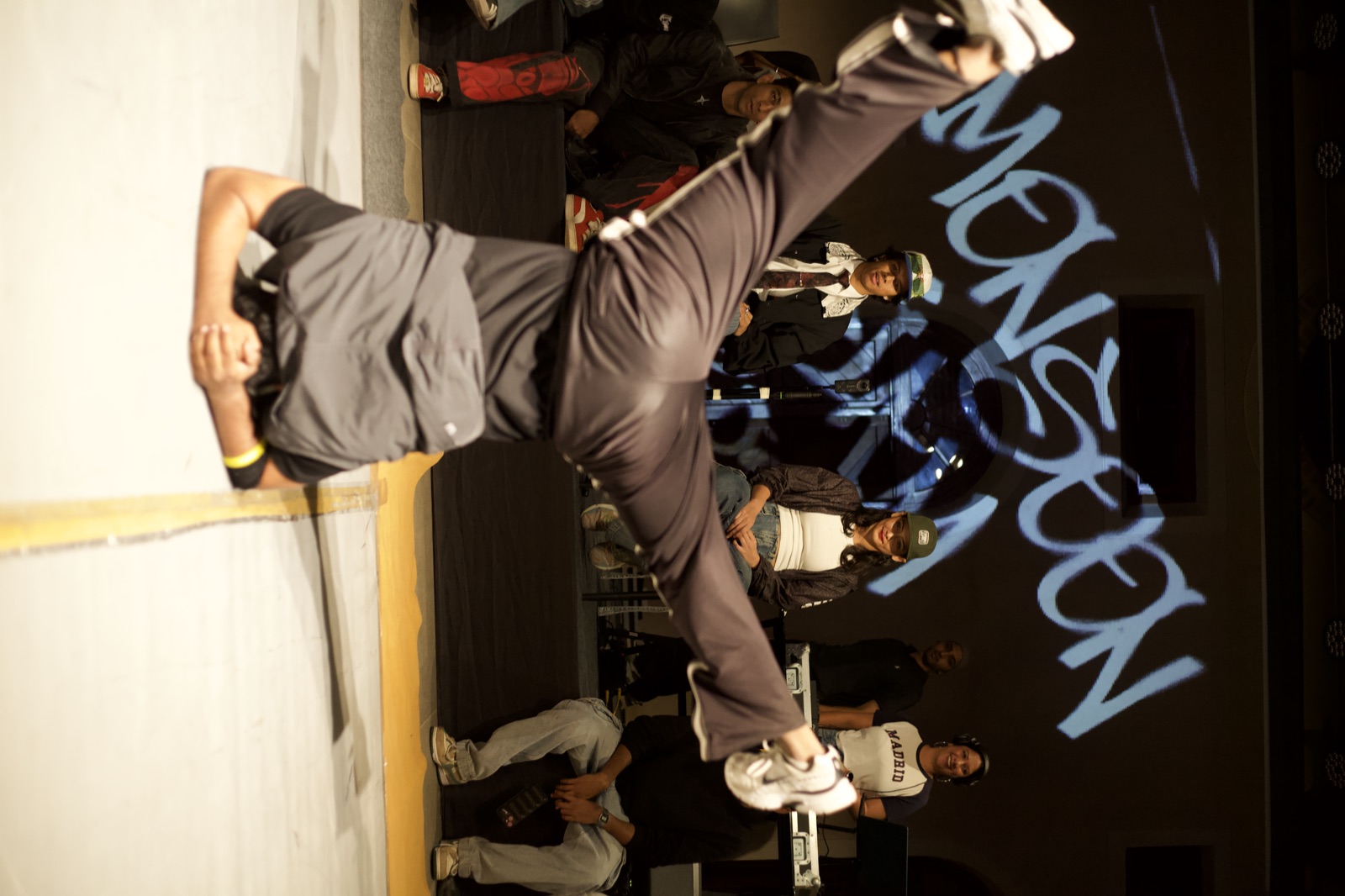 A dancer's legs scissoring mid-air in front of the judges